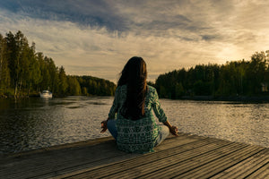Femme relaxation sur ponton devant un lac et une forêt